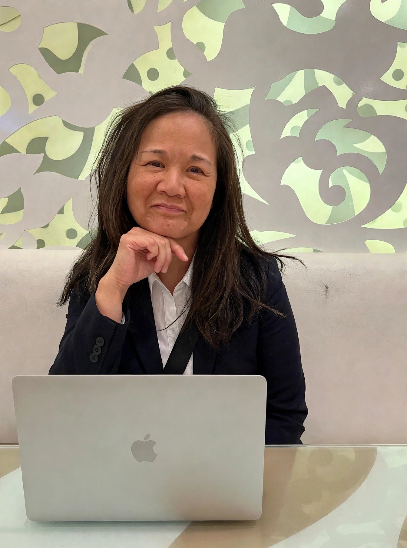 Anh Lang, mortgage broker with TMG Mortgages in Edmonton, seated with her laptop